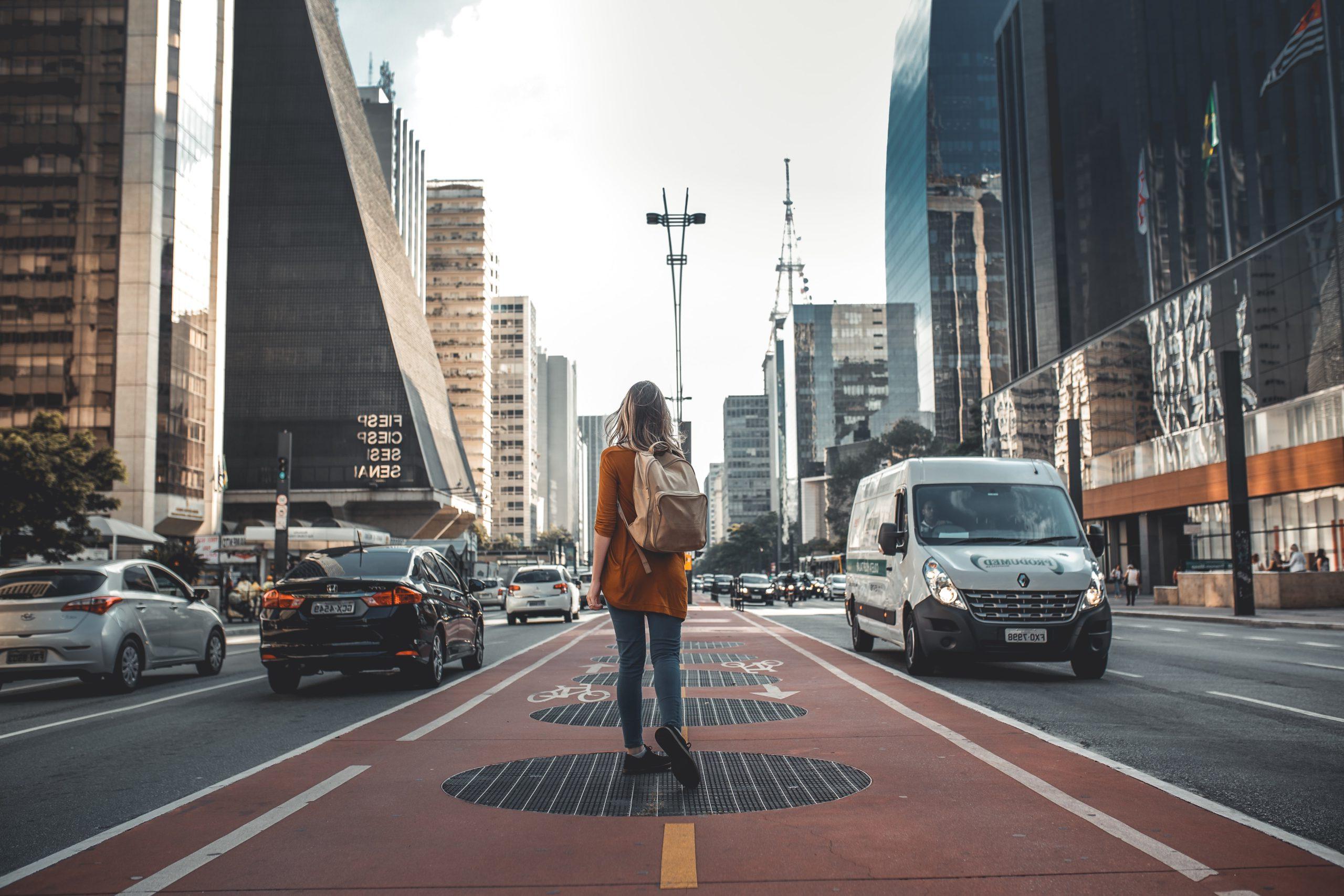Photo of a women standing in the middle of a big city