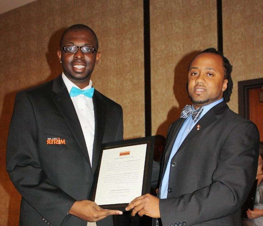 Photo of Rashad Anderson standing next to his mentor receiving a plaque.